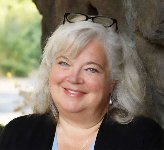 Two people study a plant in a greenhouse.